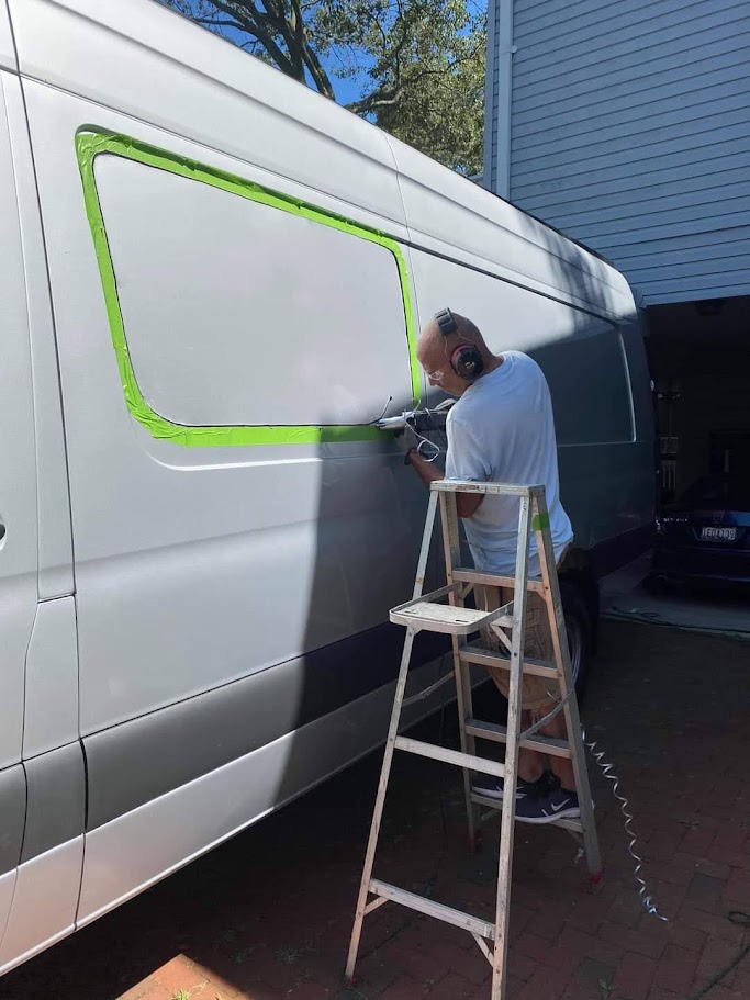 Window opening being cut into the side of the van during the build